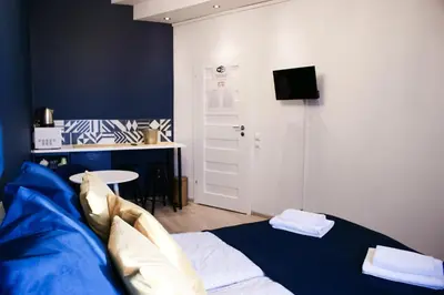 a bedroom with a bed and a desk and a tv at EURO-ROOM in Kraków