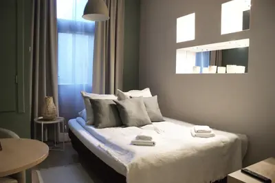 a bedroom with a bed with white sheets and pillows at EURO-ROOM in Kraków