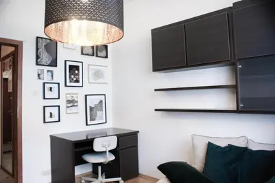 a living room with a desk and a chandelier at EURO-ROOM in Kraków