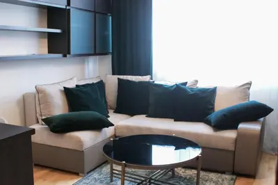 a living room with a couch with green pillows at EURO-ROOM in Kraków