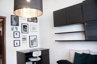 a living room with a desk and a chandelier at EURO-ROOM in Kraków