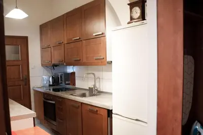 a kitchen with wooden cabinets and a sink at EURO-ROOM in Kraków
