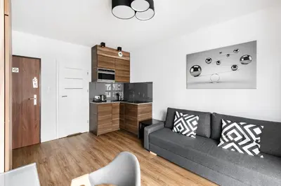 a living room with a desk and a bedroom at Apartamenty Platinex 2 in Kraków