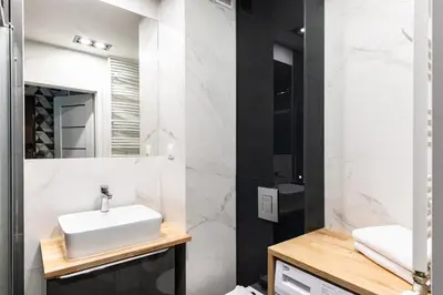 a white bathroom with a sink and a mirror at Apartamenty Platinex 2 in Kraków