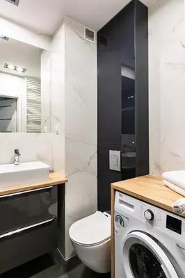 a bathroom with a toilet sink and a washing machine at Apartamenty Platinex 2 in Kraków