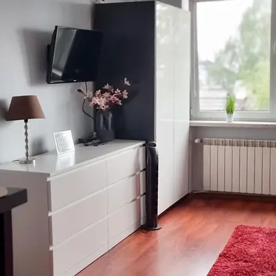 a table and two chairs in a room with two windows at Fredry 15F in Kraków