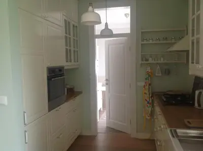 a kitchen with white cabinets and an open door at Apartament Joanna in Rabka