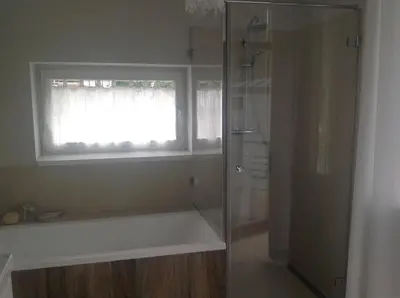 a bathroom with a shower and a window and a bath tub at Apartament Joanna in Rabka
