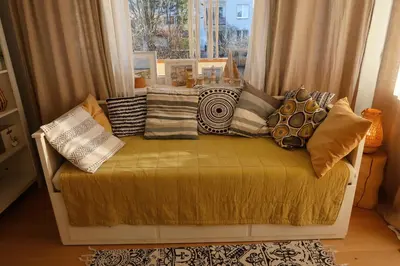 a bench with pillows on it in front of a window at Apartament Joanna in Rabka