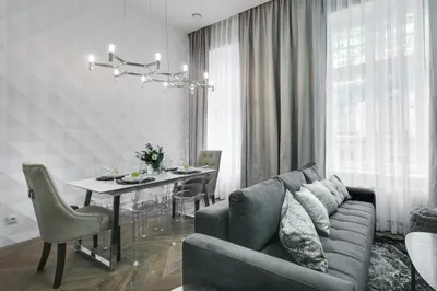 a kitchen and living room with a couch and a table at Kings City - Zyblikiewicza 14 apartment in Kraków
