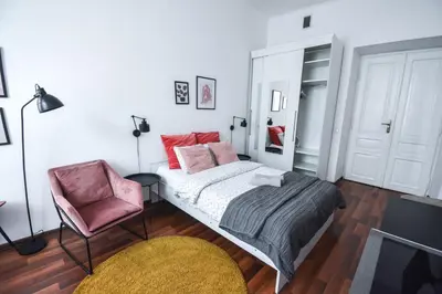 a bedroom with a bed and a chair at LION apartments - LaBA in Kraków
