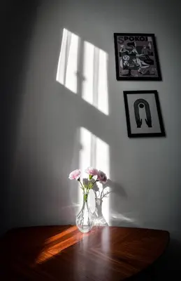 a vase with flowers on a table in a room at LION apartments - LaBA in Kraków