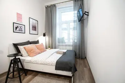 a small bedroom with a bed and a window at LION apartments - LaBA in Kraków