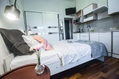 a bedroom with a bed with a vase of flowers on a table at LION apartments - LaBA in Kraków