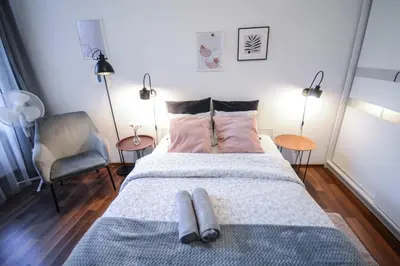 a bedroom with a bed with two pillows on it at LION apartments - LaBA in Kraków