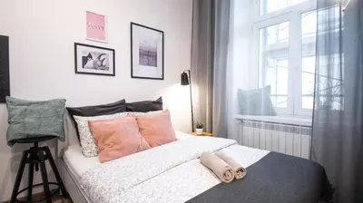 a bedroom with a bed with flip flops on it at LION apartments - LaBA in Kraków