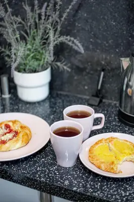 two cups of coffee and two plates of food on a table at LION apartments - LaBA in Kraków