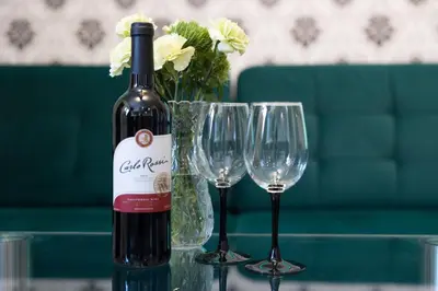 a bottle of wine and two wine glasses on a table at AgroPrzystań in Zubrzyca Górna