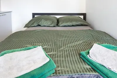 a bed with two pillows and two towels on it at AgroPrzystań in Zubrzyca Górna