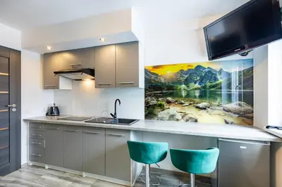a kitchen with a counter with two blue chairs at AgroPrzystań in Zubrzyca Górna