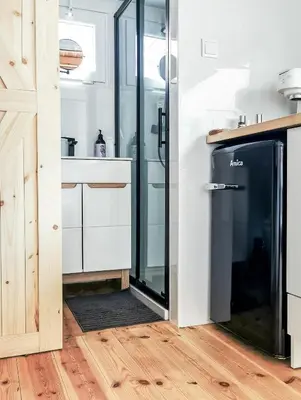 a kitchen with a glass shower and a refrigerator at LushHills - Tiny House - Modern House On Wheels in Regulice