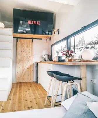 a tiny house with a kitchen and a bar at LushHills - Tiny House - Modern House On Wheels in Regulice