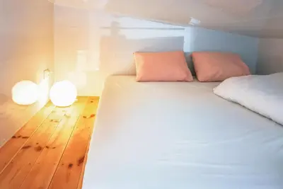 a bedroom with a white bed and two lights on the floor at LushHills - Tiny House - Modern House On Wheels in Regulice