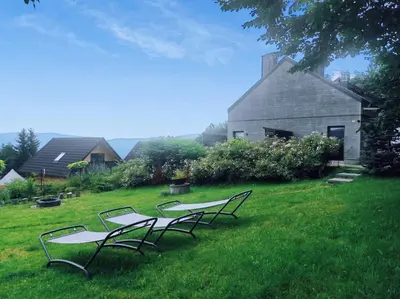 four chairs sitting in the grass in front of a barn at Słoneczny Chełm - Apartamenty w górach, Prywatna sauna jacuzzi balia w cenie, Spa, Grill, Stok narciarski Myślenice, Ścieżki rowerowe, Rzeka Raba, Widok na Tatry in Myślenice