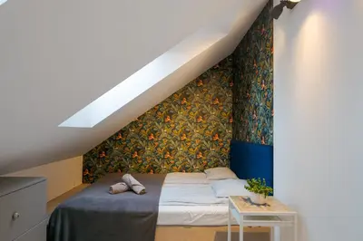 a bedroom with a bed with a floral accent wall at Słoneczny Chełm - Apartamenty w górach, Prywatna sauna jacuzzi balia w cenie, Spa, Grill, Stok narciarski Myślenice, Ścieżki rowerowe, Rzeka Raba, Widok na Tatry in Myślenice