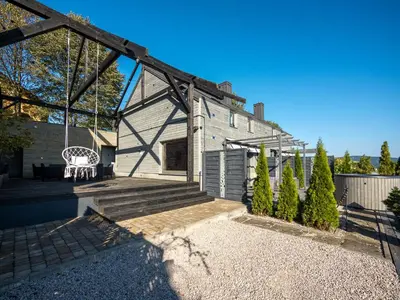 an exterior view of a house with a swing at Słoneczny Chełm - Apartamenty w górach, Prywatna sauna jacuzzi balia w cenie, Spa, Grill, Stok narciarski Myślenice, Ścieżki rowerowe, Rzeka Raba, Widok na Tatry in Myślenice