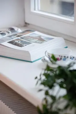 a book sitting on a table next to a cup and a plate at Apartment Pijarska Kraków by Noclegi Renters in Kraków