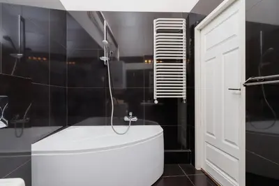 a bathroom with a white tub and a shower at Apartment Pijarska Kraków by Noclegi Renters in Kraków