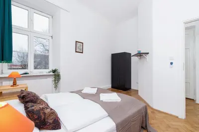 a white bedroom with a bed and a window at Apartment Pijarska Kraków by Noclegi Renters in Kraków