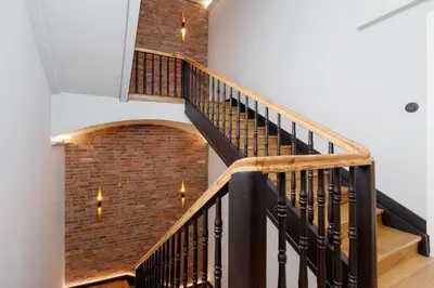 a staircase with a brick wall and lights at Apartment Pijarska Kraków by Noclegi Renters in Kraków