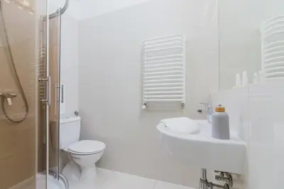 a white bathroom with a toilet and a sink at Apartment Pijarska Kraków by Noclegi Renters in Kraków