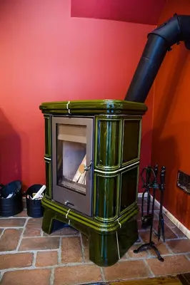 a green stove sitting on top of a brick floor at Domki na Mosornym in Zawoja