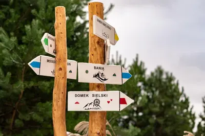 a wooden pole with street signs on it at Domki na Mosornym in Zawoja