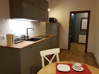 a kitchen with a table and a sink and a counter top at Zakamarki in Kraków