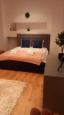 a bedroom with a bed with blue pillows and a rug at Villa pod Szczeblem Dom dla 12 osób z kominkiem balią jacuzzi in Kasinka Mala