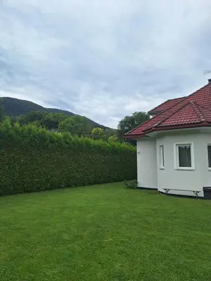 a white house with a bench in a yard at Villa pod Szczeblem Dom dla 12 osób z kominkiem balią jacuzzi in Kasinka Mala