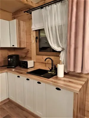 a kitchen with white cabinets and a sink and a window at Dom na Wichrowym Wzgórzu in Łętownia Dolna