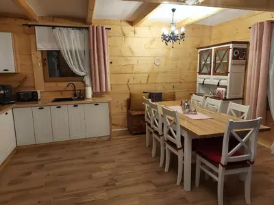 a kitchen and dining room with a table and chairs at Dom na Wichrowym Wzgórzu in Łętownia Dolna