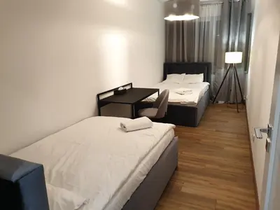 a hotel room with two beds and a desk at Lovely Apartment near Wawel in Kraków