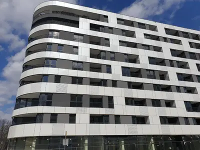 a tall white building with black windows at Lovely Apartment near Wawel in Kraków
