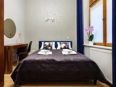 a bedroom with a blue bed with towels on it at CracWoW Market Squere Apartment in Kraków