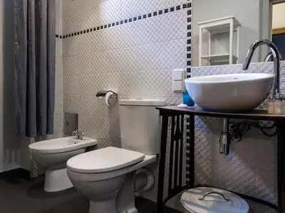 a bathroom with a white toilet and a sink at CracWoW Market Squere Apartment in Kraków