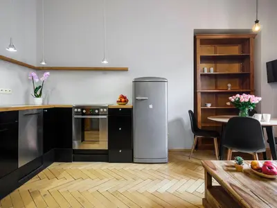 a kitchen with a refrigerator and a table at CracWoW Market Squere Apartment in Kraków