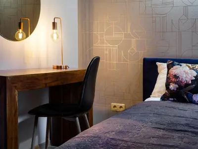 a bedroom with a desk and a bed and a chair at CracWoW Market Squere Apartment in Kraków
