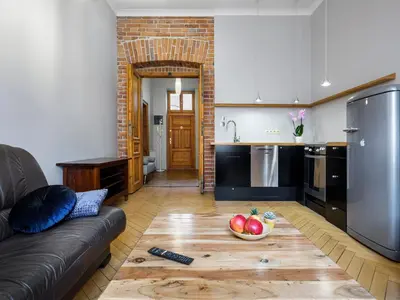 a kitchen with a couch and a bowl of fruit on a table at CracWoW Market Squere Apartment in Kraków