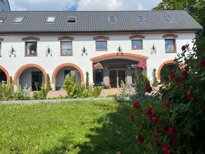 a large white house with a yard with flowers at U Kowola - Gospodarstwo Agroturystyczne in Węglówka